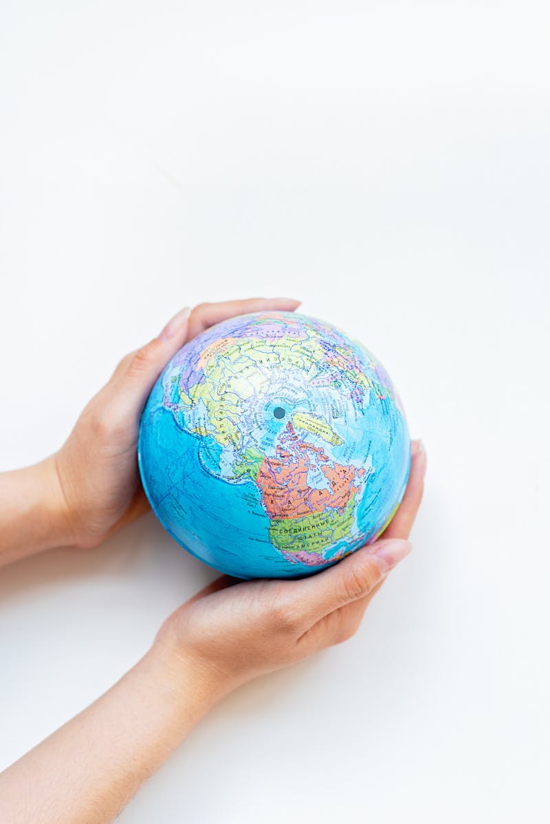 Person using smartphone next to a globe representing international communication